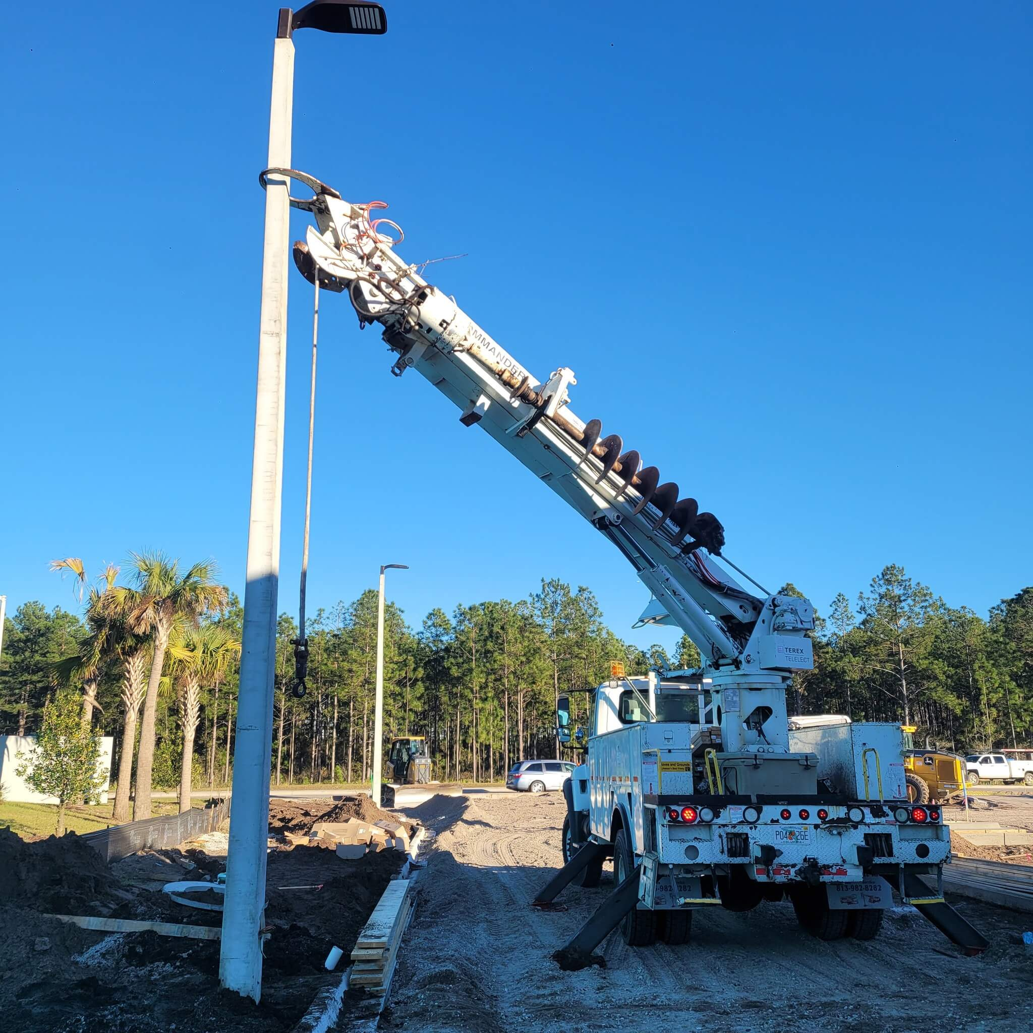 Light pole setting service near me by South Florida Pole Setters and Crane Service, Inc. in Stuart, FL with crane and equipment