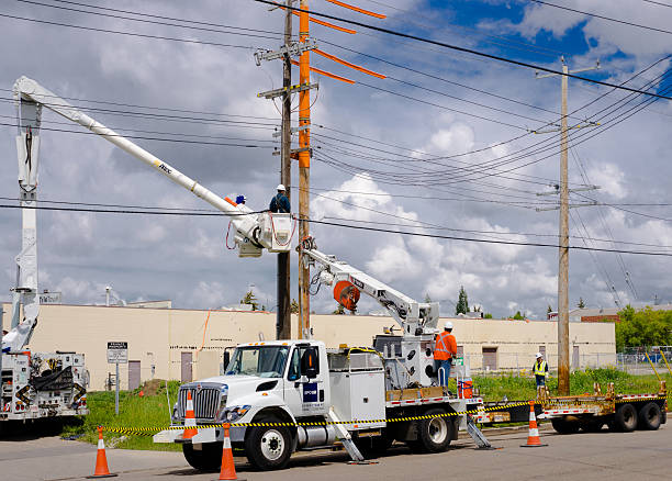 Pole replacement service by South Florida Pole Setters and Crane Service near me, featuring workers using a crane on electric poles in Stuart, FL.