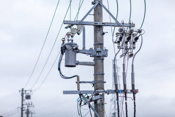 Workers following safety measures during utility pole installation process.