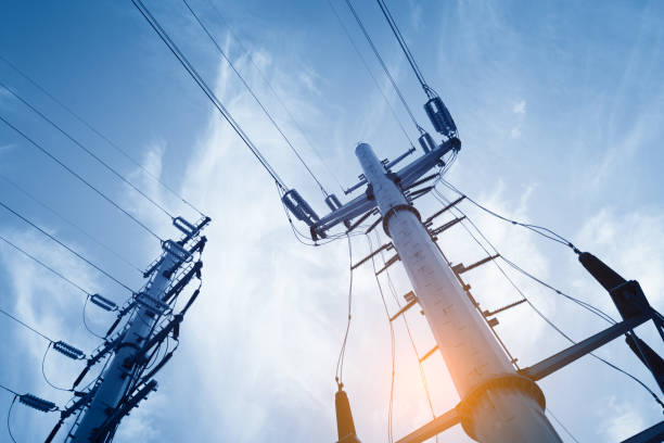 Professional electricians and crew performing power pole installation for commercial property.