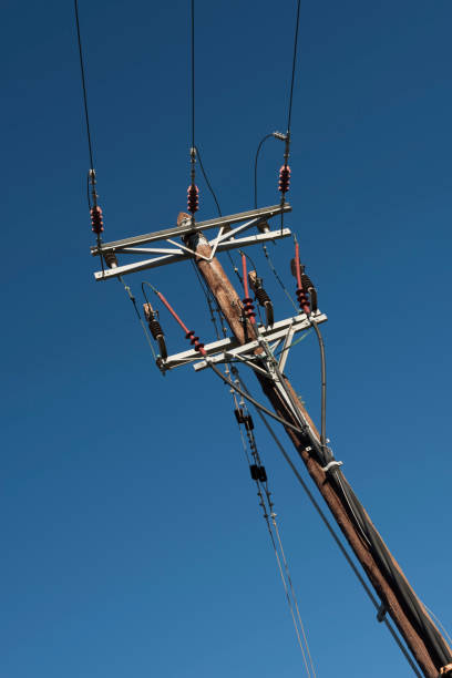 Power pole installation team preparing site for electrical connections